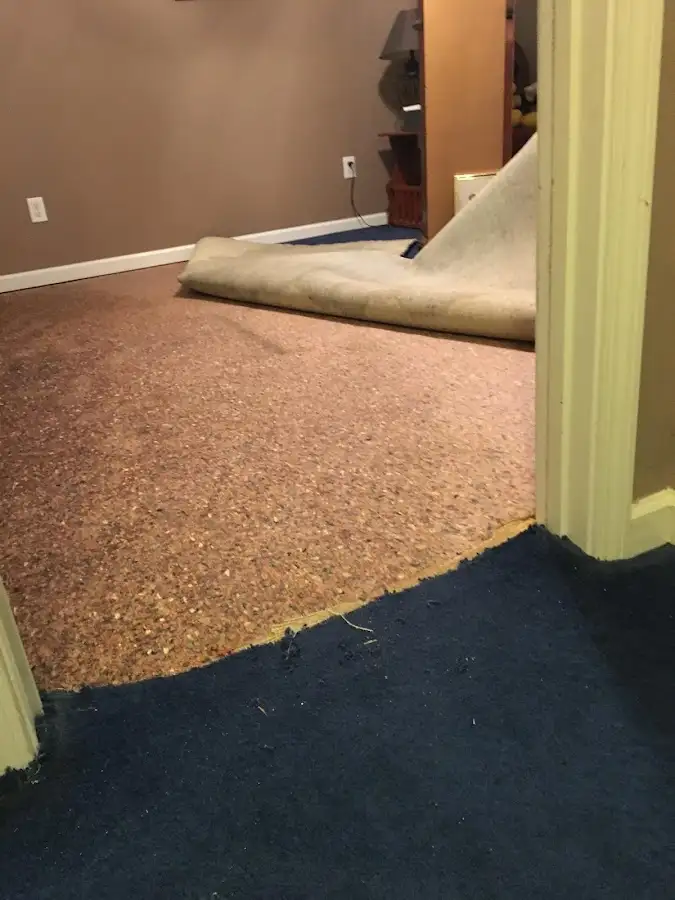 Carpet pad removal revealing water damage during Water Mitigation Services in Mecca